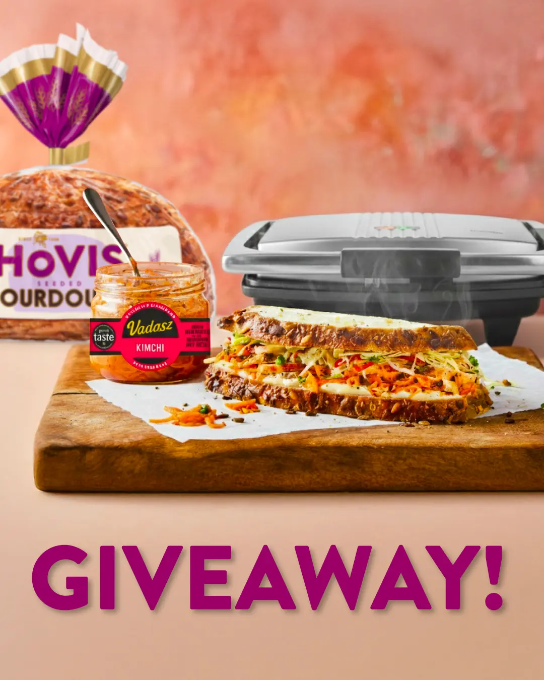 A promotional giveaway image featuring a Hovis sourdough loaf, Vadasz kimchi jar, sandwich press, and a fresh sandwich.