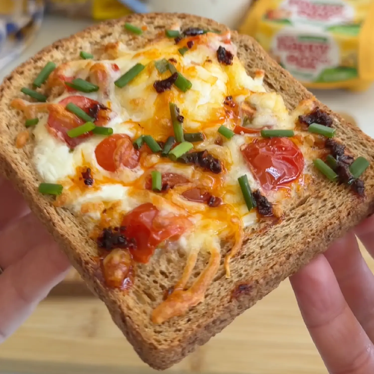 Crispy wholemeal egg-in-a-hole toast topped with melted cheese, juicy cherry tomatoes, fresh chives and chilli oil.