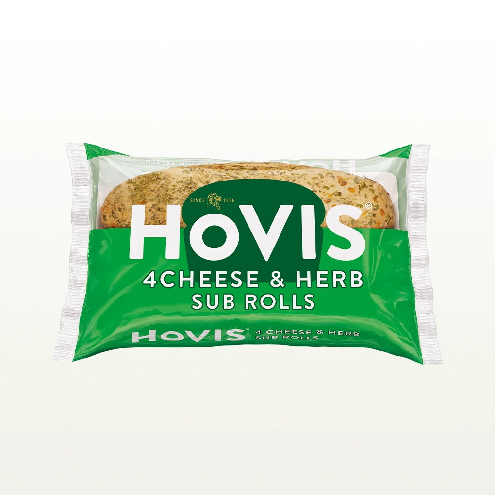 The pack shows two soft sub rolls with herbs and highlights “Deliciously soft fusion of cheese and herbs.” The pack sits on a white backdrop with a subtle shadow.
