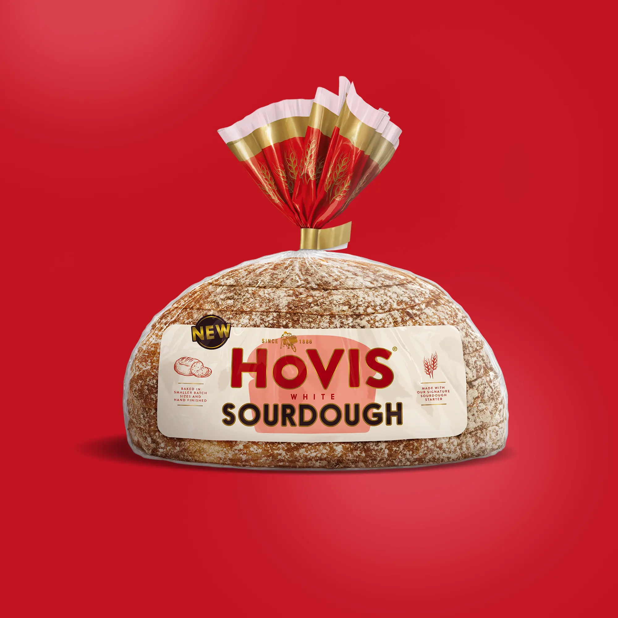 A loaf of Hovis White Sourdough bread is displayed on a red background. The packaging features a white and red design with a gold trim and nutrition information. A 'NEW' label is shown on the top corner of the pack