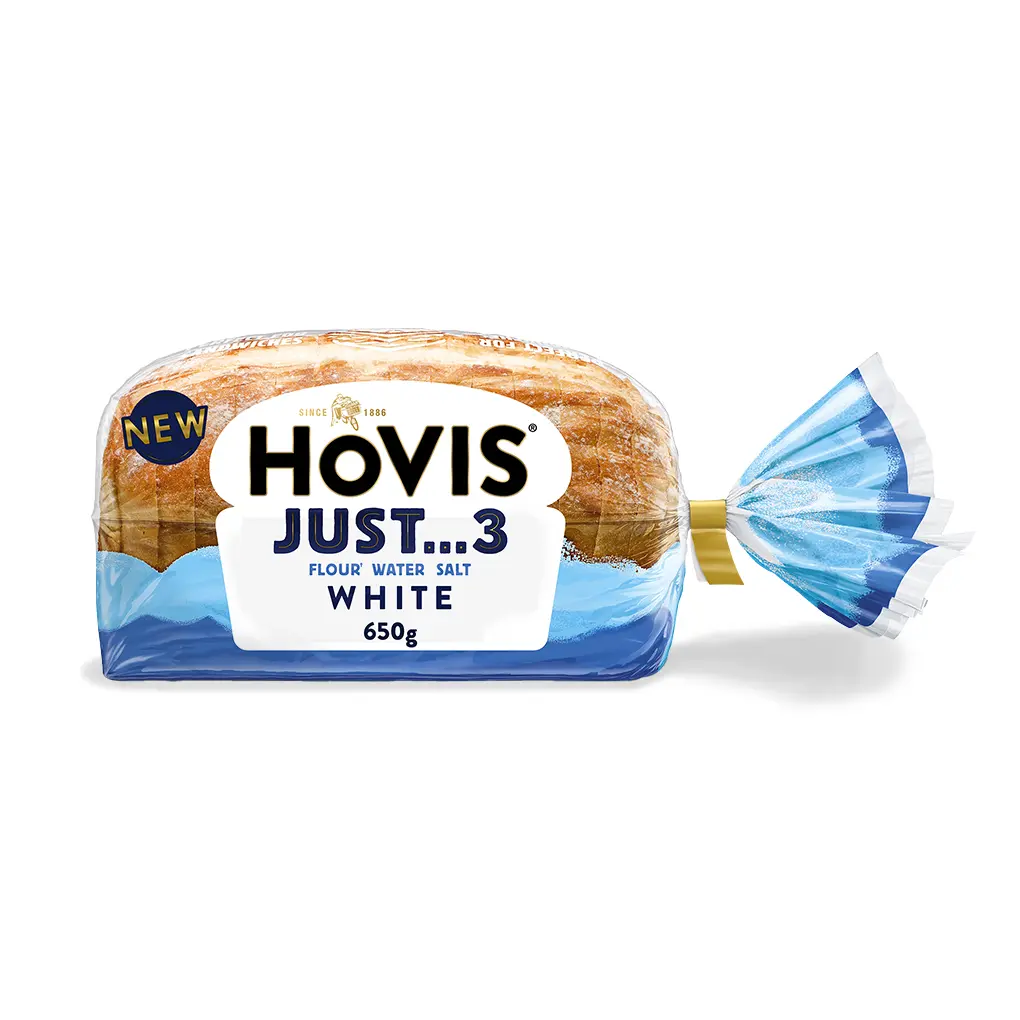A loaf of Hovis Just 3 sliced white bread inside clear and light-blue plastic packaging tied with a yellow clip on the right.