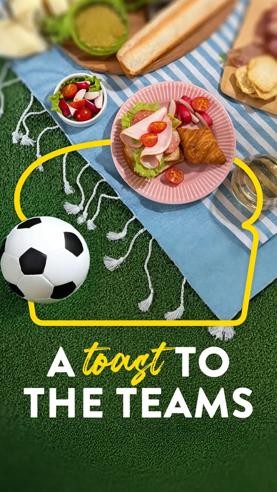 A picnic setup on green grass with a blue striped blanket holding a plate of sandwiches topped with lettuce, ham, and cherry tomatoes, along with a croissant and radishes. A bowl of salad sits nearby, and a foot ball rests on the grass. The text at the bottom reads ‘A toast to the teams’ with the word ‘toast’ in yellow script.