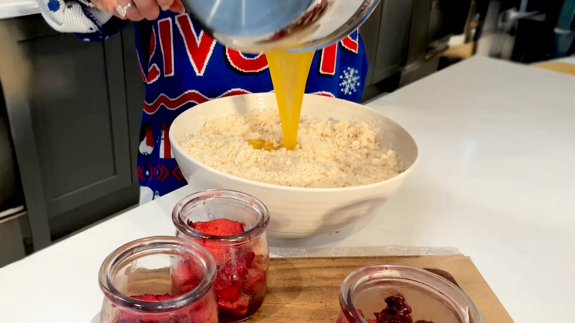 Melted butter being poured into a bowl of blitzed Hovis® breadcrumbs mixed with sugar, cinnamon, and a pinch of salt, ready to form the crumble topping.