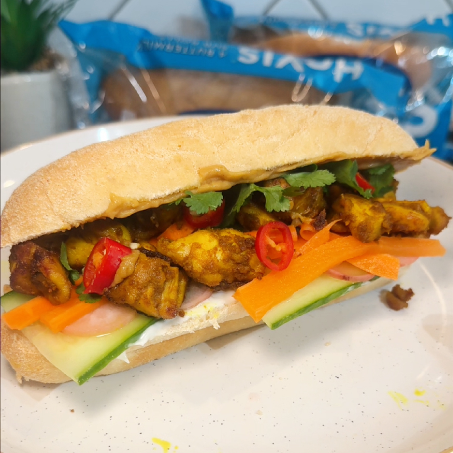 A delicious chicken satay sub roll made using Hovis Buttermilk sub rolls. Sliced in half, on a plate