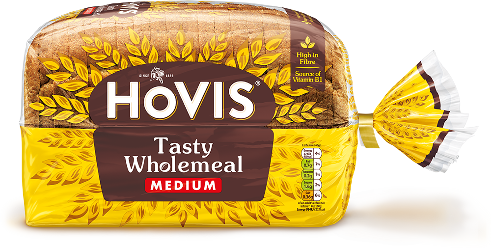 Hovis Tasty Wholemeal Medium Sliced bread on a white backdrop with a subtle shadow. The packaging is half transparent and half yellow, decorated with golden wheats.